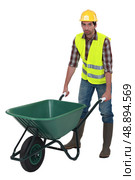 Labourer pushing a wheelbarrow. Стоковое фото, агентство Ingram Publishing / Фотобанк Лори