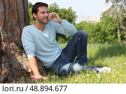 Man sitting by a tree. Стоковое фото, агентство Ingram Publishing / Фотобанк Лори