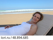 Woman lying on sun lounger. Стоковое фото, агентство Ingram Publishing / Фотобанк Лори