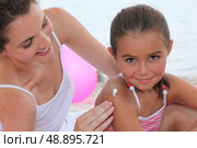 Mother putting suncream on her daughter. Стоковое фото, агентство Ingram Publishing / Фотобанк Лори