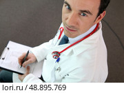 a doctor writing on a paper. Стоковое фото, агентство Ingram Publishing / Фотобанк Лори
