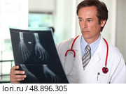Doctor looking at X-ray. Стоковое фото, агентство Ingram Publishing / Фотобанк Лори