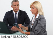 Business partners using calculator. Стоковое фото, агентство Ingram Publishing / Фотобанк Лори