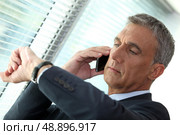 Businessman looking at his watch. Стоковое фото, агентство Ingram Publishing / Фотобанк Лори