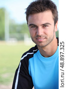 Young soccer player stood by pitch. Стоковое фото, агентство Ingram Publishing / Фотобанк Лори