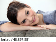 Woman lying on couch. Стоковое фото, агентство Ingram Publishing / Фотобанк Лори