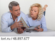 Couple looking at a catalogue. Стоковое фото, агентство Ingram Publishing / Фотобанк Лори