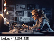 In a dimly lit workshop brimming with design schematics, an absorbed engineer meticulously assembles a complex model, embodying epitome of concentration and innovation under soft glow of desk lamp. Стоковое AI-изображение, AI-художник Данила Большаков / Фотобанк Лори