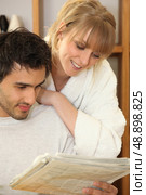 Young couple looking at a morning paper. Стоковое фото, агентство Ingram Publishing / Фотобанк Лори