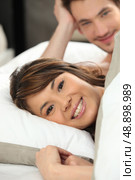 Happy young couple laying in bed. Стоковое фото, агентство Ingram Publishing / Фотобанк Лори