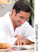 smiling man in robe reading. Стоковое фото, агентство Ingram Publishing / Фотобанк Лори