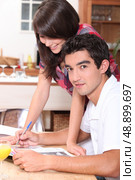 Couple writing on atable. Стоковое фото, агентство Ingram Publishing / Фотобанк Лори