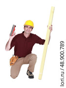 Carpenter kneeling with wood. Стоковое фото, агентство Ingram Publishing / Фотобанк Лори
