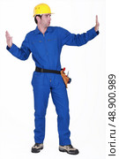 Tradesman pushing invisible walls. Стоковое фото, агентство Ingram Publishing / Фотобанк Лори