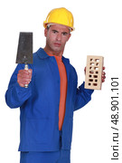 Angry tradesman holding a brick and trowel. Стоковое фото, агентство Ingram Publishing / Фотобанк Лори