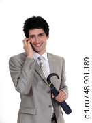 Businessman holding an umbrella and talking on a mobile phone. Стоковое фото, агентство Ingram Publishing / Фотобанк Лори