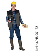 Mason holding brick and angle grinder. Стоковое фото, агентство Ingram Publishing / Фотобанк Лори