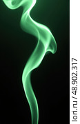 Graceful Green Smoke Streams Swirl on a Black Background, Evoking Lightness and Fluidity in Art and Design. Стоковое AI-изображение, AI-художник Sergey Grishin / Фотобанк Лори