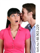 Man whispering into a woman’s ear. Стоковое фото, агентство Ingram Publishing / Фотобанк Лори