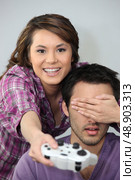 Young couple larking about with a games console. Стоковое фото, агентство Ingram Publishing / Фотобанк Лори