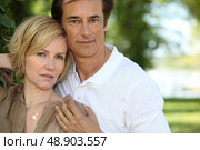 Sultry couple stood by tree in park. Стоковое фото, агентство Ingram Publishing / Фотобанк Лори