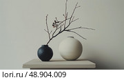 Two vases, one tall and slender, the other short and wide, are placed neatly on a wooden table. Стоковое AI-изображение, AI-художник Данила Большаков / Фотобанк Лори
