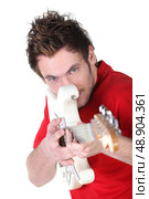 Young man playing the guitar. Стоковое фото, агентство Ingram Publishing / Фотобанк Лори