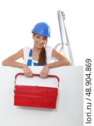 Pretty young woman with a red toolbox and a board left blank for your image. Стоковое фото, агентство Ingram Publishing / Фотобанк Лори
