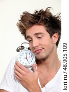 Sleepy man hugging his alarm clock. Стоковое фото, агентство Ingram Publishing / Фотобанк Лори