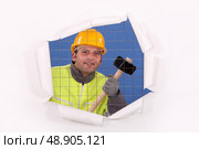 A man with a sledgehammer behind a wire netting. Стоковое фото, агентство Ingram Publishing / Фотобанк Лори