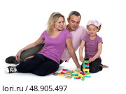 Parents watching their daughter play with blocks. Стоковое фото, агентство Ingram Publishing / Фотобанк Лори