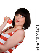 brunette wearing striped sleeveless top lifting dumbbell. Стоковое фото, агентство Ingram Publishing / Фотобанк Лори