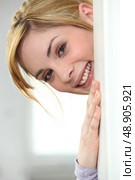 Blonde woman peeking behind the wall. Стоковое фото, агентство Ingram Publishing / Фотобанк Лори
