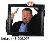 Black man hanging frame. Стоковое фото, агентство Ingram Publishing / Фотобанк Лори