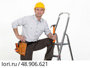 Handyman posing with his tools and a stepladder. Стоковое фото, агентство Ingram Publishing / Фотобанк Лори