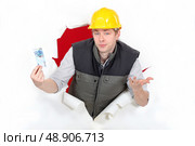 Workers coming out of torn paper hole with ticket in hand. Стоковое фото, агентство Ingram Publishing / Фотобанк Лори
