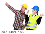 Construction worker pointing out a problem while his co-worker denies any involvement. Стоковое фото, агентство Ingram Publishing / Фотобанк Лори