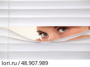 Woman peering through blinds. Стоковое фото, агентство Ingram Publishing / Фотобанк Лори