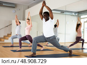 African american standing in Ashta Chandrasana with hands in prayer above head. Стоковое фото, фотограф Яков Филимонов / Фотобанк Лори