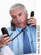 Overwhelmed white collar worker answering telephones. Стоковое фото, агентство Ingram Publishing / Фотобанк Лори