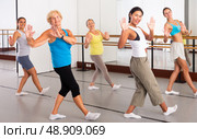Women practicing vigorous dance movements in group dance class. Стоковое фото, фотограф Яков Филимонов / Фотобанк Лори
