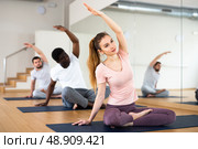 Woman doing stretching in Padmasana pose in yoga studio. Стоковое фото, фотограф Яков Филимонов / Фотобанк Лори