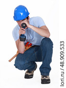 A man using his drill as a gun. Стоковое фото, агентство Ingram Publishing / Фотобанк Лори