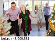 Middle-aged man and elderly woman are dancing contemporary twist in couple in Christmas atmosphere. Стоковое фото, фотограф Яков Филимонов / Фотобанк Лори