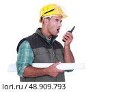 Tradesman yelling into a walkie-talkie. Стоковое фото, агентство Ingram Publishing / Фотобанк Лори