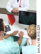 Medical assistant looking at his reflection on a computer screen. Стоковое фото, агентство Ingram Publishing / Фотобанк Лори