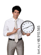 Office worker pointing his finger to a clock. Стоковое фото, агентство Ingram Publishing / Фотобанк Лори