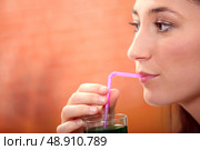 Woman drinking green drink. Стоковое фото, агентство Ingram Publishing / Фотобанк Лори