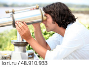 Man looking through a telescope. Стоковое фото, агентство Ingram Publishing / Фотобанк Лори