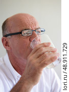 Elderly man drinking a glass of water. Стоковое фото, агентство Ingram Publishing / Фотобанк Лори